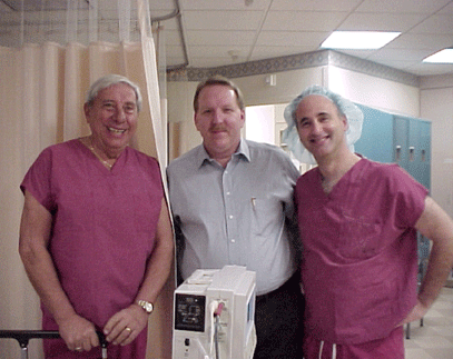 Dr. “G” (left) and Dr. Lewis (right) surround Victor Krzesinski, RN, director of nursing at the Wills Eye surgical facility