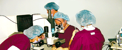 Sue Cross (LASIK coordinator and patient advocate, left) assists James Lewis, MD (center) during laser eye surgery in Philadelphia. Dawn Cacia, RN (right) prepares the microkeratome and Robert Czajkowski (first assistant, background) runs the Nidek EC-5000 computer and excimer laser.